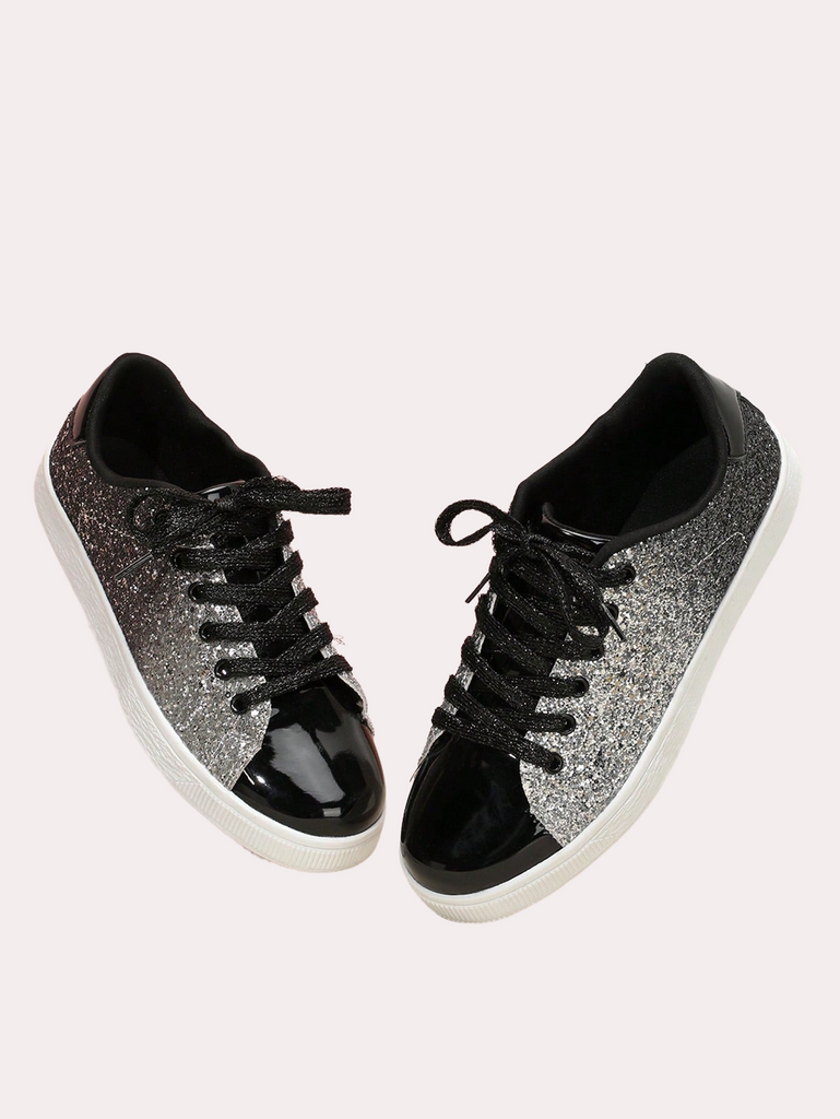 a pair of black and silver sneakers on a white background