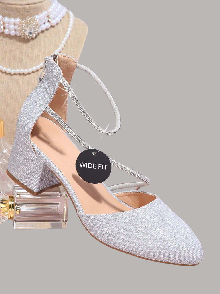 a woman's white high heeled shoe next to a bottle of perfume