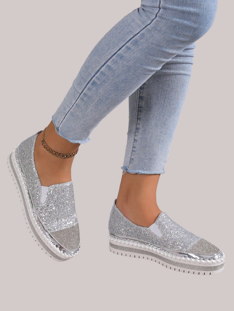 a woman's feet wearing silver glitter shoes