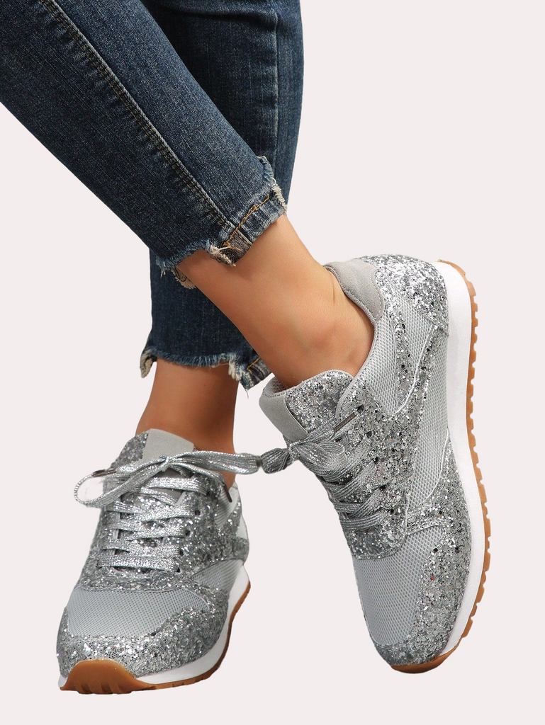 a woman's feet wearing silver sneakers