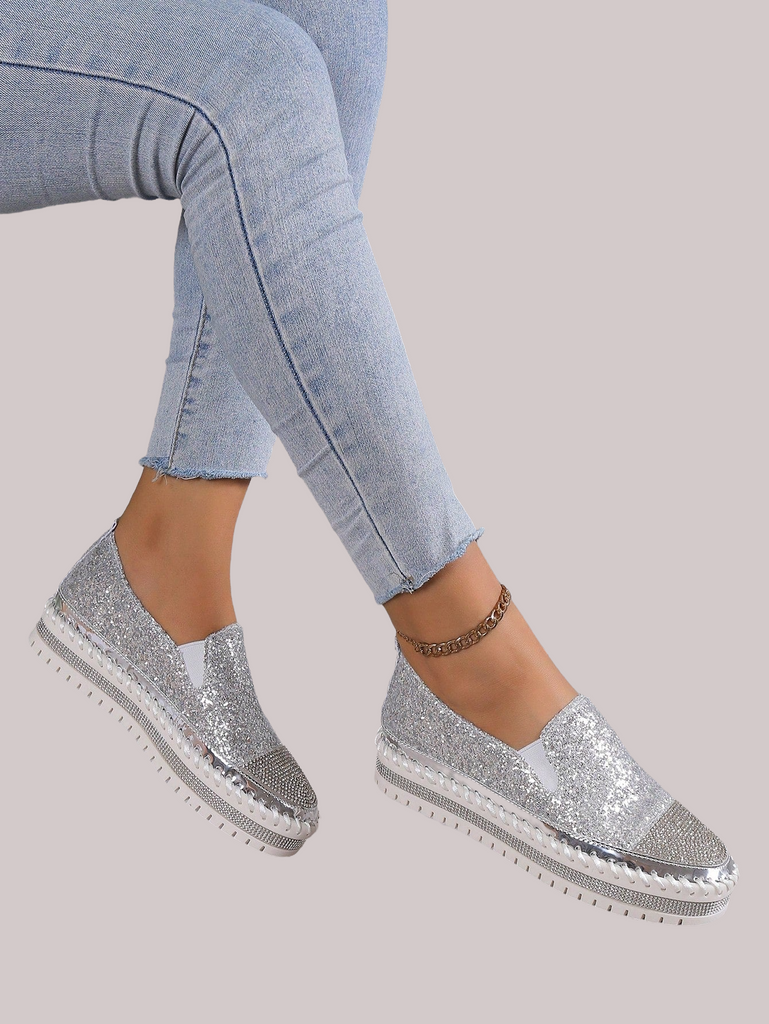 a woman's feet wearing silver glitter shoes