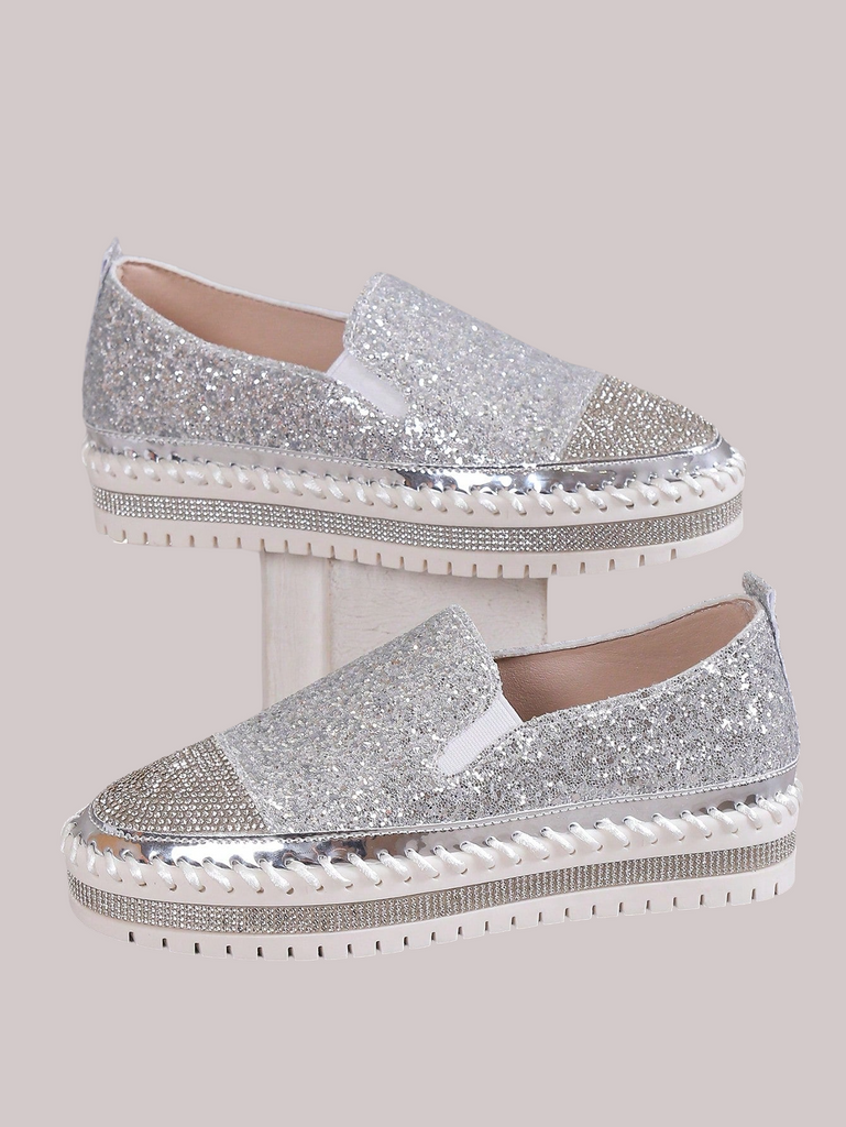 a pair of silver glitter shoes with white soles