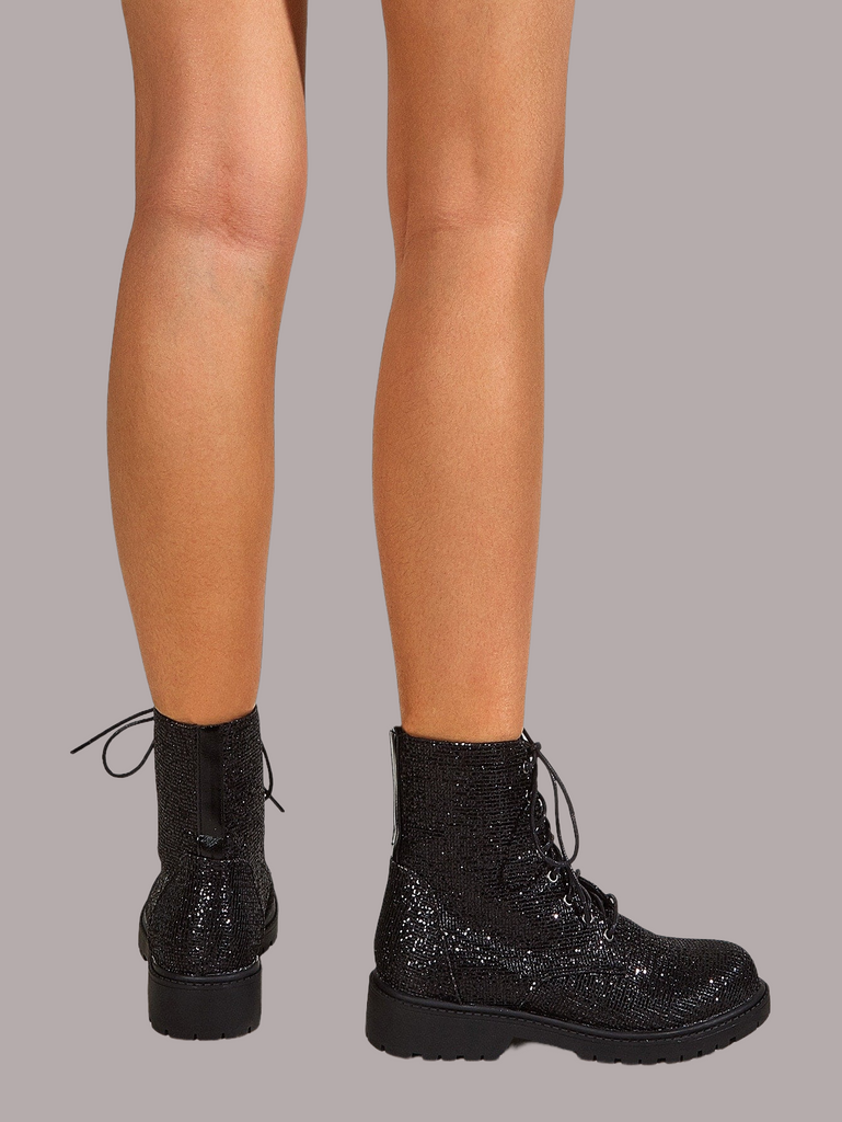 a close up of a person's legs wearing black boots